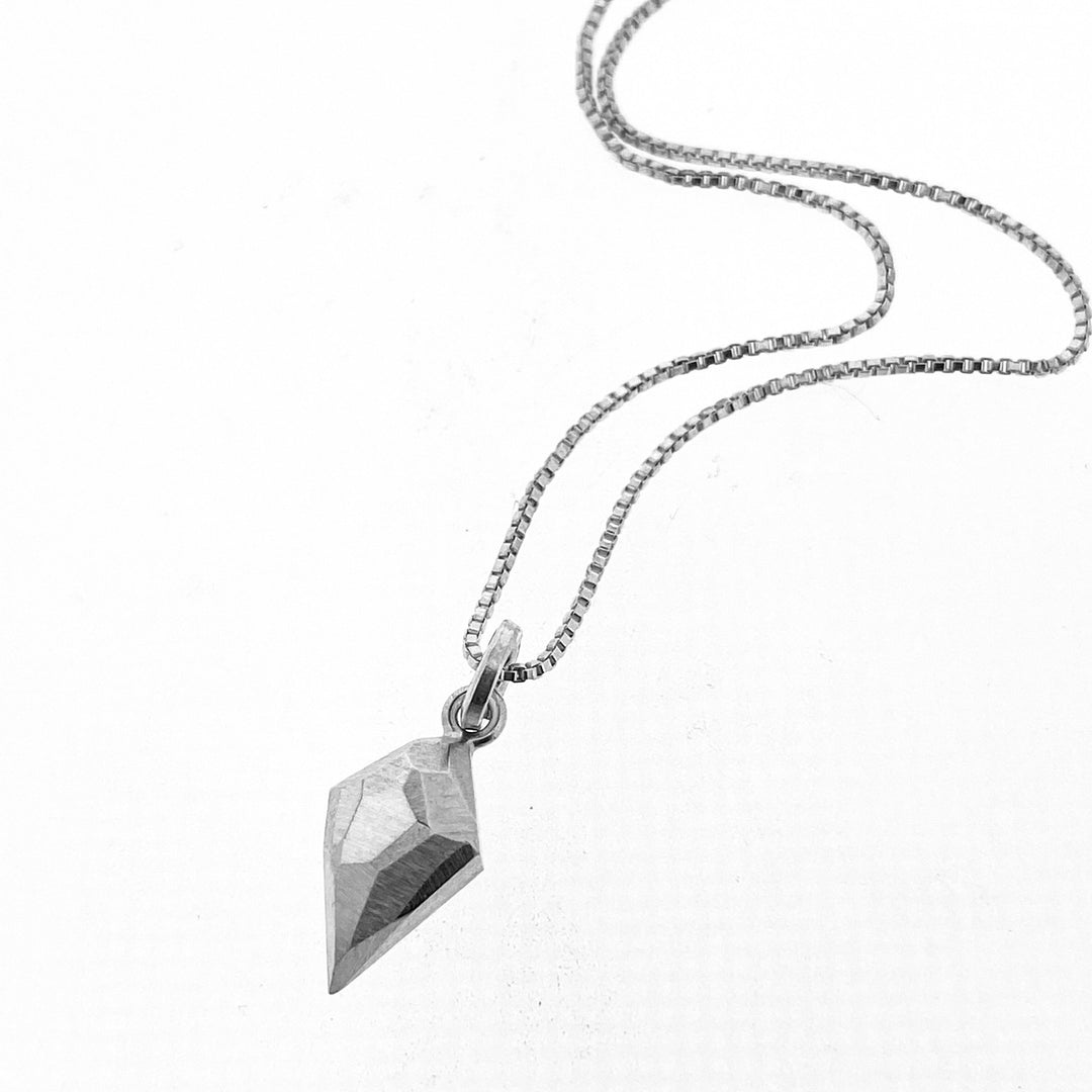 Full view of diamond shaped pendant on silver chain.