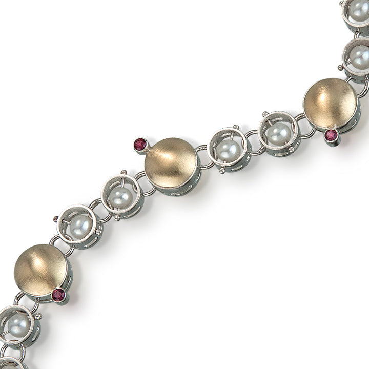 Detail photo of Sterling & 18k gold circle linked bracelet with pearls and garnet gemstones.