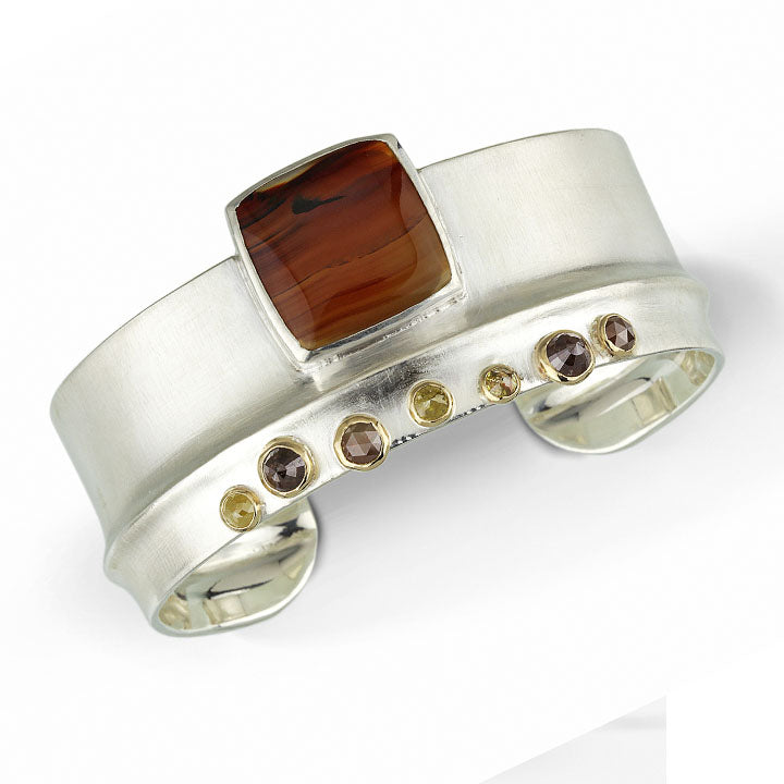 Full image of Montana Agate and Rose Cut Diamonds on Ridge Cuff. This cuff has a set square of montana agate at its center, slightly hanging off the cuff, and opposing the square are seven set naturally colored rose cut diamonds (all set in gold) that all lay on a silver band.