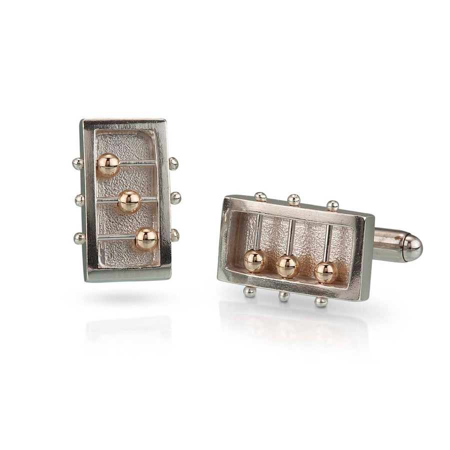 Full view of Rectangle Abacus Cufflinks. these cufflinks are made of silver, in the shape of a rectangle with three silver wires running through their middle that has a free floating gold bead strung on them.