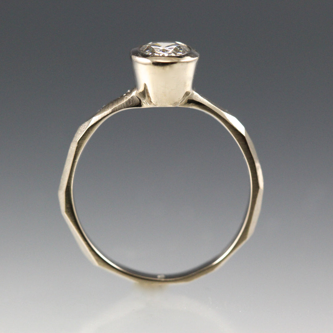 Side view of a 14k white gold Bezel Set Oval Engagement Ring featuring a organic faceted band.