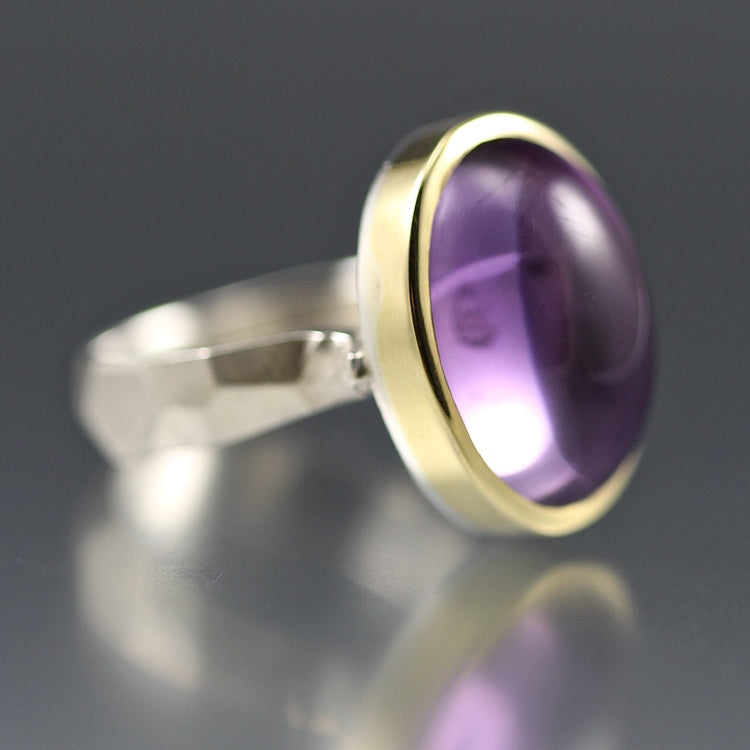 Side view of Amethyst Chiseled Ring with gold encompassing amethyst oval on a silver chiseled band.