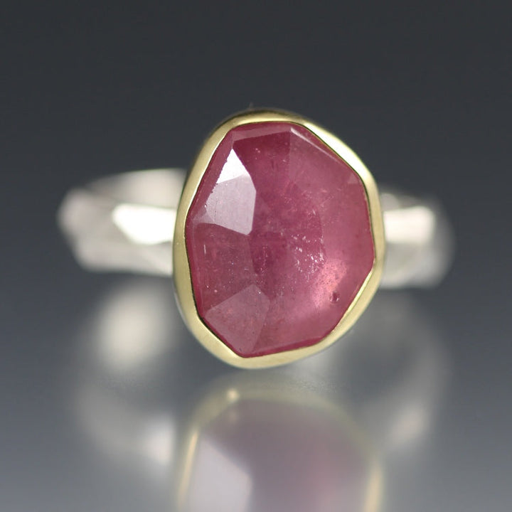 Detail shot of Rose Cut Pink Sapphire Chiseled Ring. This ring showcases a pink sapphire that is set in gold on top of a silver chiseled band.
