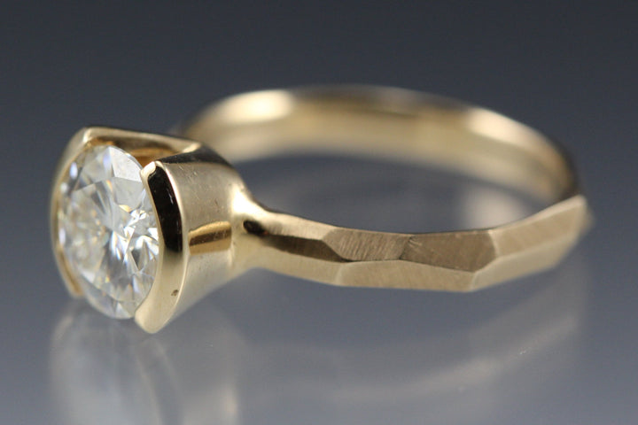 Side view of a Modern 14k yellow gold Engagement Ring with a Partial Bezel containing a Moissanite Stone with a faceted band.
