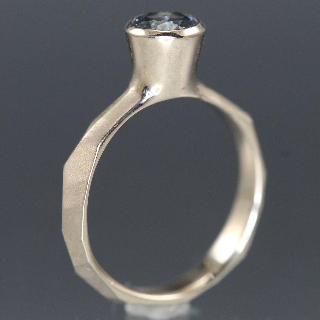 Side view of Montana Blue Sapphire Chiseled Ring that showcases its setting of its sapphire which appears to be hidden in a cone of white palladium gold.