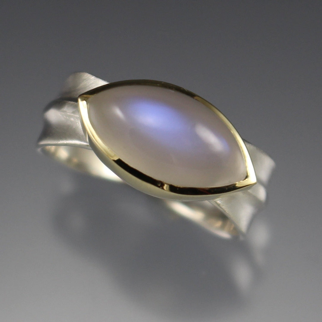 Full image of Moonstone Ridge Ring. The moonstone is cut in the shape of a marquise and is set in gold on a silver band that resembles a leaf's spine.