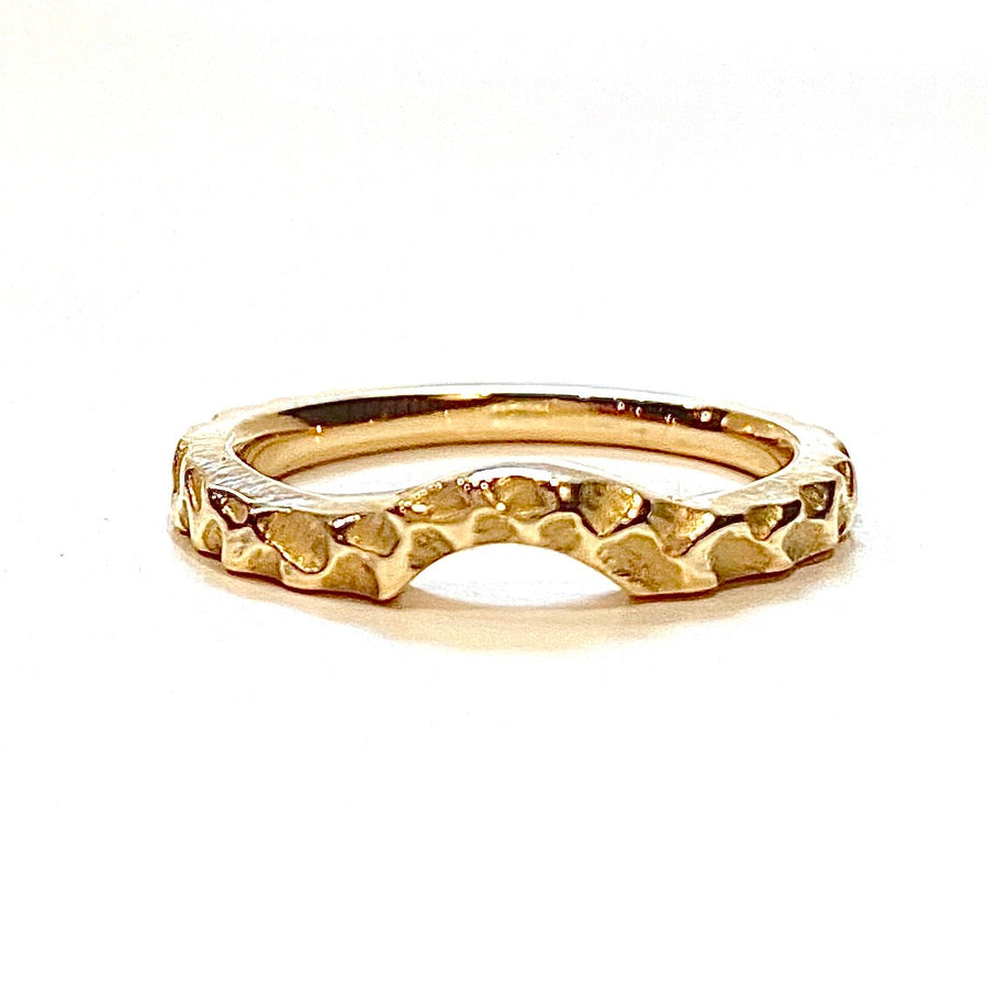 Full image of Contoured Cobblestone Ring. this wedding band is gold with an arch at the front and has a texture cobblestone pattern within it.