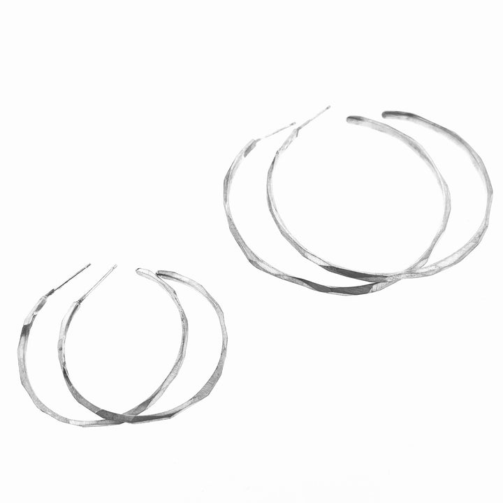 Full view of large and medium faceted hoop earrings next to one another.