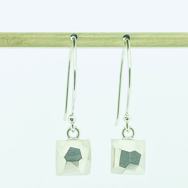 Full view of square faceted dangle earrings hanging from an earring post.