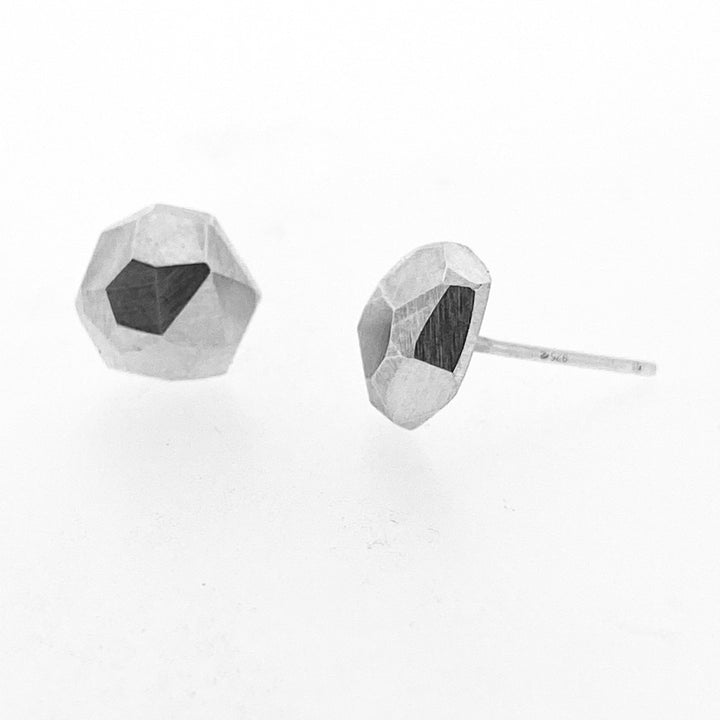 Full image of faceted stud earrings - circle. One is showcasing its side profile while the other its front.