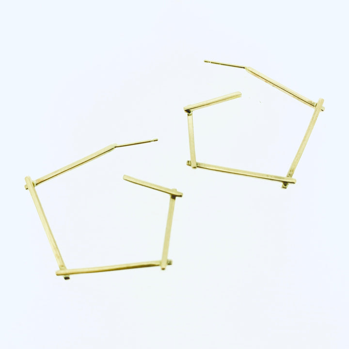 Full view of gold small stick hoop earrings.