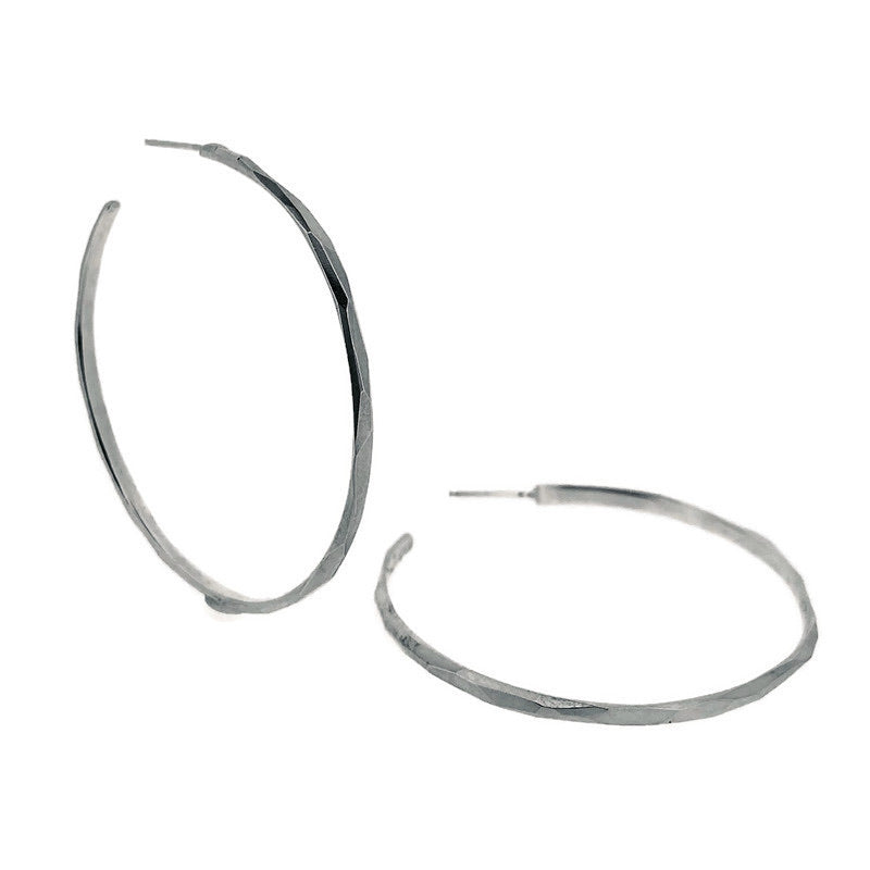 Full view of Faceted Hoop Earrings (large). Silver hoop earrings with a faceted texture.