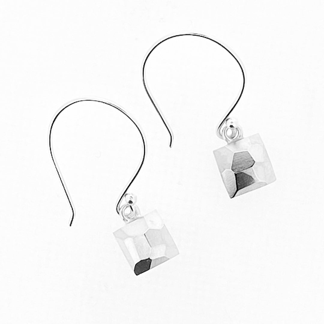 Full view of Faceted Dangle Earrings in the shape of a square. They hang from large earring hoops and have a faceted texture.