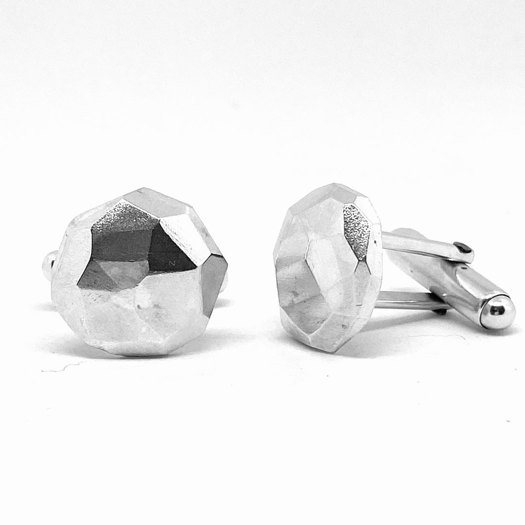 Full view of faceted Cufflinks at an angle on a white background.