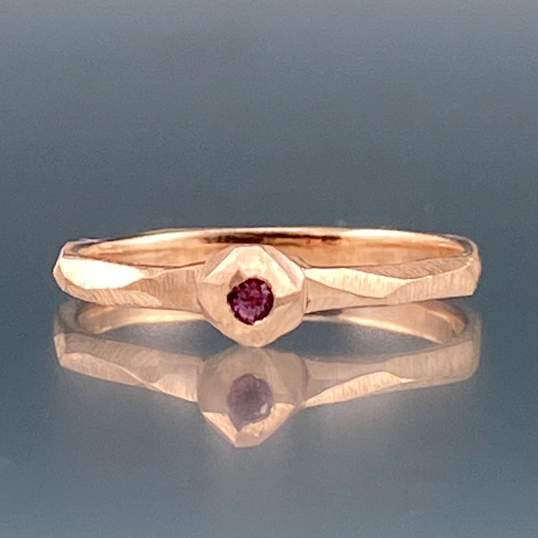 Full image of pink sapphire nugget facet ring laying down.