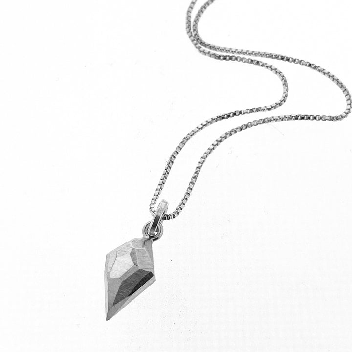 Full view of diamond shaped pendant on silver chain.