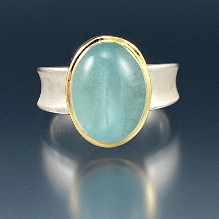 Full view of Aquamarine Valley Ring. The pendant is of an ovular aquamarine encompassed in gold on a silver band.